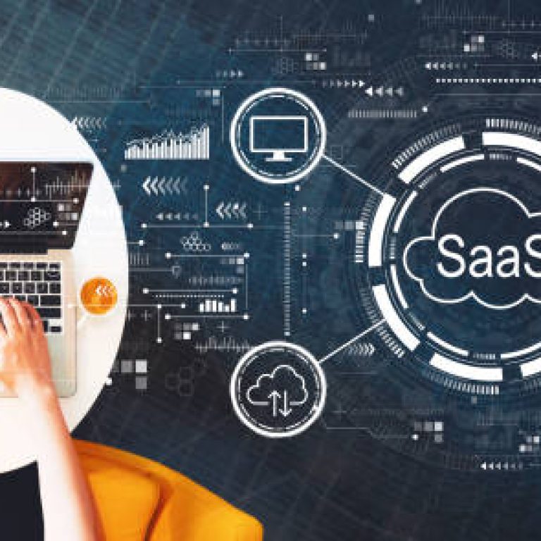 SaaS - software as a service concept with person using a laptop on a white table